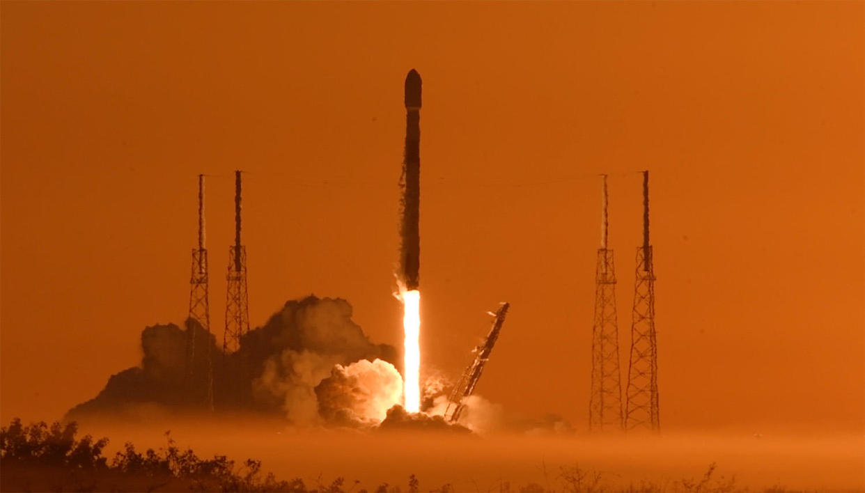 A SpaceX Falcon 9 rocket carrying a GPS 3 navigation satellite climbs away from a low fog bank at the Cape Canaveral Space Force Station minutes after sunrise.  / Credit: William Harwood/CBS News