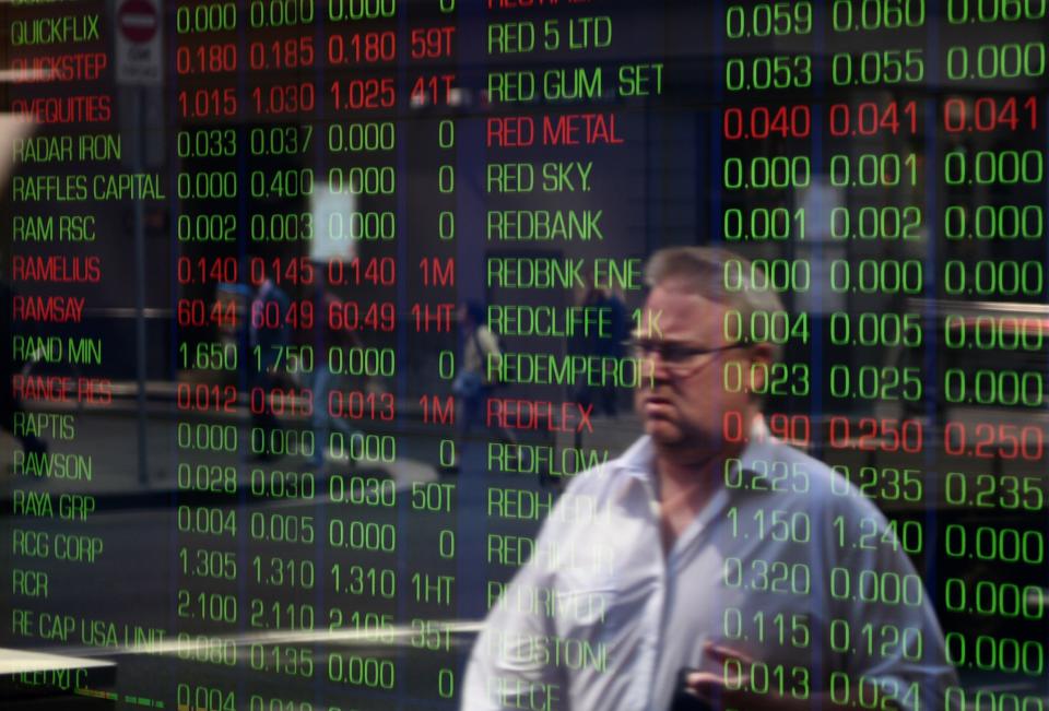 A passerby is reflected in the window of the Sydney Stock Exchange showing the benchmark S&P/ASX200 index in Sydney on September 18, 2015. Australian stocks slipped 0.28 percent at the open after the US Federal Reserve left interest rates near zero overnight.    AFP PHOTO / Peter PARKS        (Photo credit should read PETER PARKS/AFP via Getty Images)