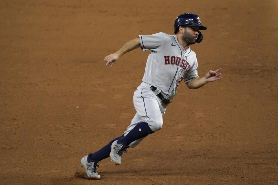 Houston Astros' Jose Altuve rounds third on his way home, scoring on a Yuli Gurriel single in the eighth inning of a baseball game against the Texas Rangers in Arlington, Texas, Friday, Sept. 25, 2020. (AP Photo/Tony Gutierrez)