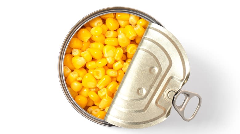 opened canned corn on a white background from above