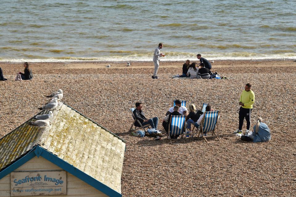 People observe social distancing on the beach  in Brighton, southern England, on May 16, 2020, following an easing of lockdown rules in England during the novel coronavirus COVID-19 pandemic. - People are being asked to "think carefully" before visiting national parks and beaches on the first weekend since coronavirus lockdown measures were partially eased in England. (Photo by Glyn KIRK / AFP) (Photo by GLYN KIRK/AFP via Getty Images)