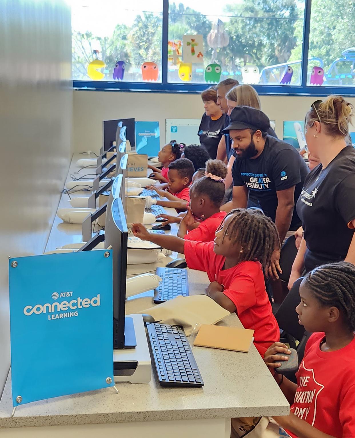 Employees of AT&T are shown volunteering at the company's new Connected Learning Center in West Palm Beach. Opened in March, this is AT&T's first such facility created as part of its commitment to bridging the digital divide.