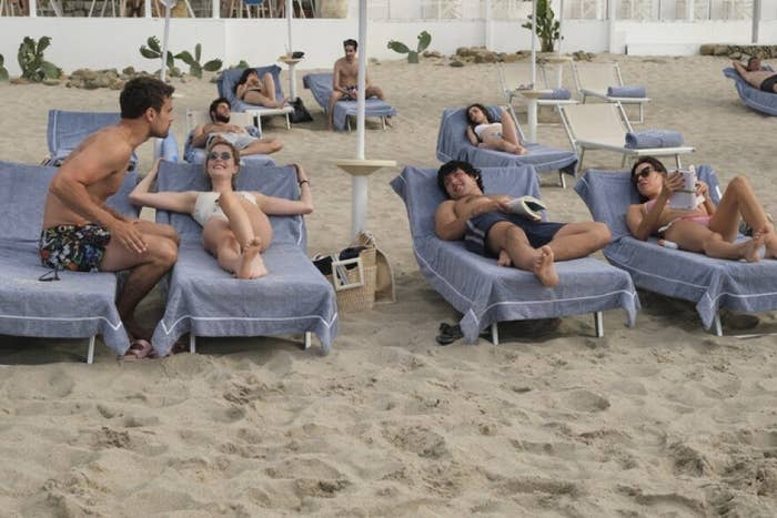 Aubrey Plaza and Will Sharpe lay on beach chairs