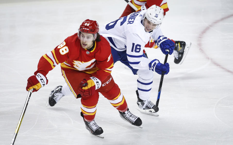 Toronto Maple Leafs' Mitchell Marner, right, chases Calgary Flames' Andrew Mangiapane during the third period of an NHL hockey game, Tuesday, Jan. 26, 2021 in Calgary, Alberta. (Jeff McIntosh/The Canadian Press via AP)