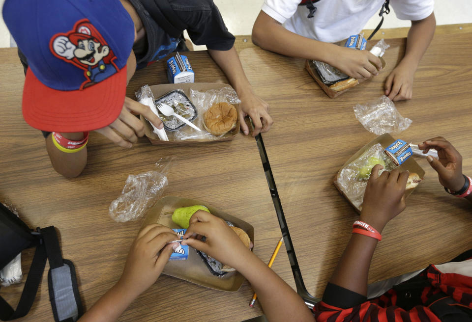 FILE - In this Sept. 4, 2013, file photo, students at the Maurice J. Tobin K-8 School in Boston's Roxbury neighborhood eat lunch. The Agriculture Department said Friday, Jan. 3, 2013, it’s making permanent rules that allow schools to serve larger portions of lean meat and whole grains in school lunches and other meals. (AP Photo/Steven Senne, File)