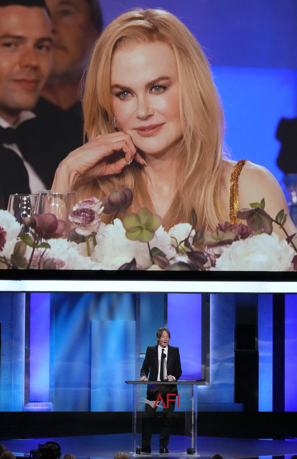 Honoree Nicole Kidman, top, is seen on a video monitor as her husband Keith Urban speaks about her during the 49th AFI Life Achievement Award tribute to Kidman, Saturday, April 27, 2024, at the Dolby Theatre in Los Angeles. (AP Photo/Chris Pizzello)