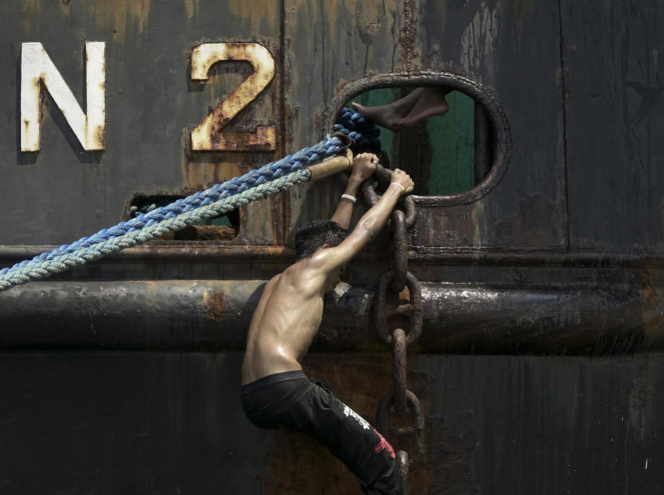 A Filipino climbs on an anchor chain of a cargo ship