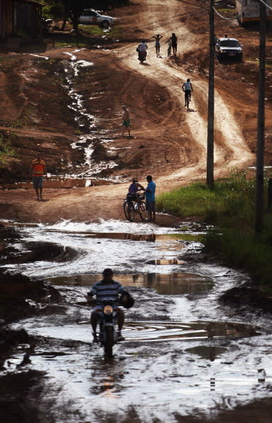 A man drives his motorcycle through a low-lying area near the area where the Belo Monte dam complex is under construction in the Amazon basin on June 16, 2012 in Altamira, Brazil.