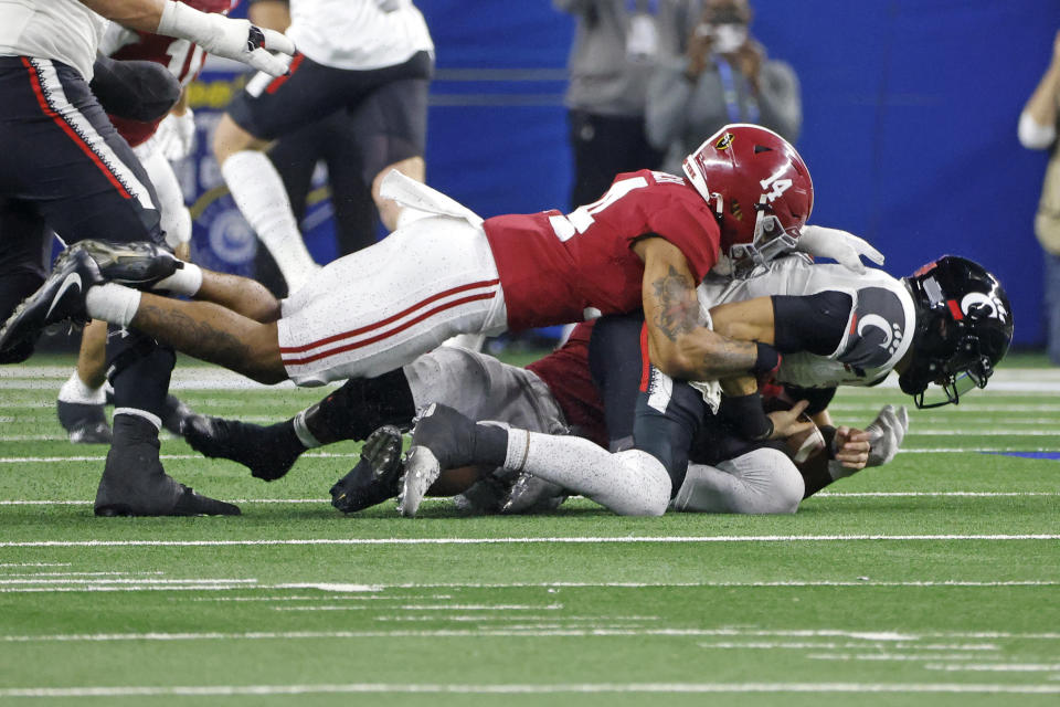 Cincinnati quarterback Desmond Ridder (9), right, is sacked by Alabama's Brian Branch (14) and Will Anderson Jr. during the second half of the Cotton Bowl NCAA College Football Playoff semifinal game, Friday, Dec. 31, 2021, in Arlington, Texas. (AP Photo/Michael Ainsworth)