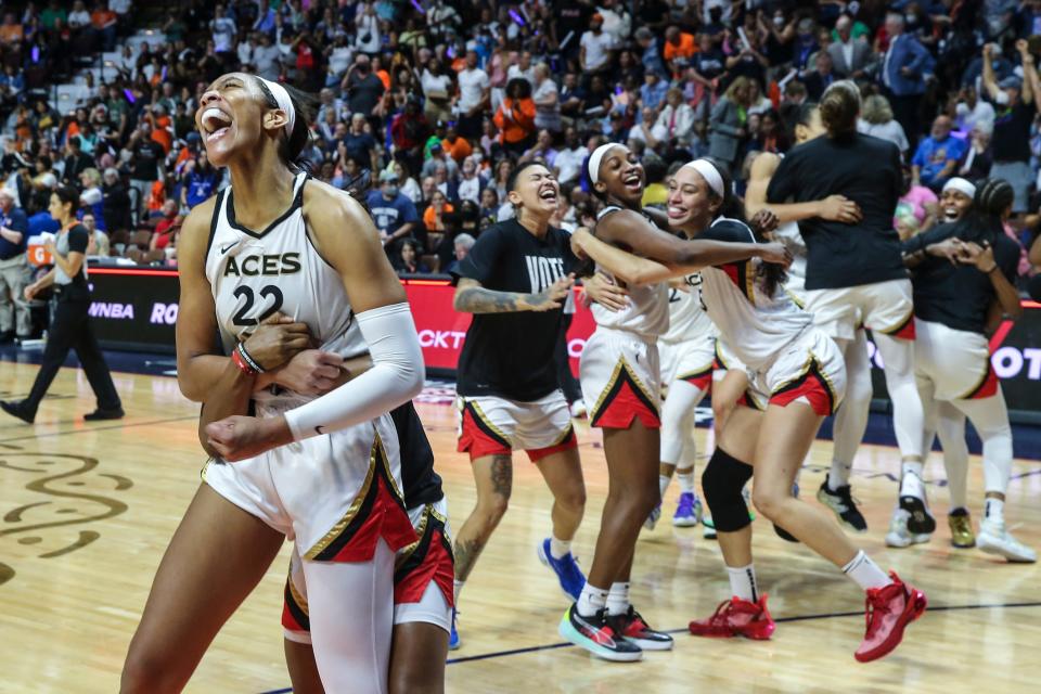 Kierstan Bell (middle, wearing T-shirt) and the rest of the Las Vegas Aces celebrate after winning the 2022 WNBA Championship with a victory over the Connecticut Sun in Game 4 of the Finals.