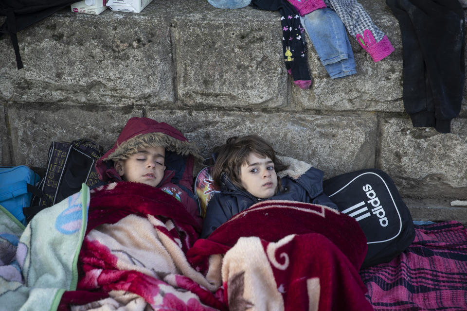 EDIRNE, TURKEY - MARCH 02: An irregular migrant child wakes up beside a sleeping child as they continue to flock at the Pazarkule Border Gate in Karaagac neighbourhood in Edirne, Turkey to reach Greece on March 02, 2020. The number of irregular migrants leaving Turkey for Europe has reached 117,677 on Monday, Turkish Interior Minister Suleyman Soylu said on Twitter. The migrants are leaving Turkey through northwestern Edirne province bordering Greece and Bulgaria. Thousands of migrants flocked to Edirne's Pazarkule border crossing to Greece after Turkish officials announced Friday they would no longer try to stop irregular migrants from reaching Europe (Photo by Gokhan Balci/Anadolu Agency via Getty Images)