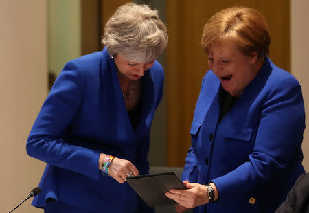 Britain's Prime Minister Theresa May and Germany's Chancellor Angela Merkel look at a tablet ahead of a European Council meeting on Brexit at the Europa Building at the European Parliament in Brussels, Belgium April 10, 2019. Kenzo Tribouillard/Pool via REUTERS