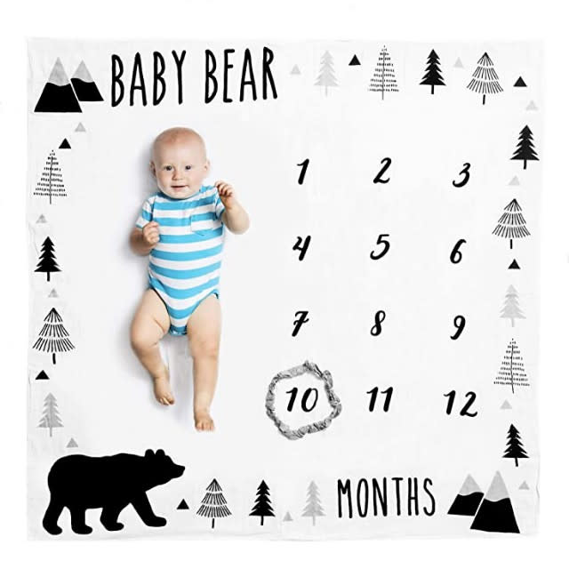 Capture the adventurous spirit of your baby boy with this mountain-filled milestone blanket. If you have a woodland-inspired nursery, this blanket will fit right in with your decor. The white blanket is made out of 100 percent organic muslin cotton, which will be gentle on your baby’s delicate skin. Your baby bear will be the center of attention during this recurring photoshoot with this blanket of contrasts. To mark the monthly milestones, there’s a gray, mountain-esque ring included with the blanket. 