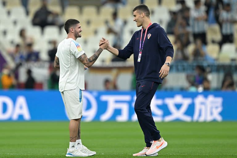 El jugador argentino Rodrigo De Paul saluda al arquero croata Ivo Grbic en la previa al partido por semifinales de la Copa del Mundo entre Argentina y Croacia