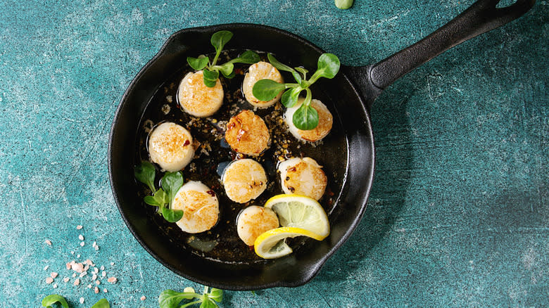 Scallops in cast iron pan with lemon and herbs