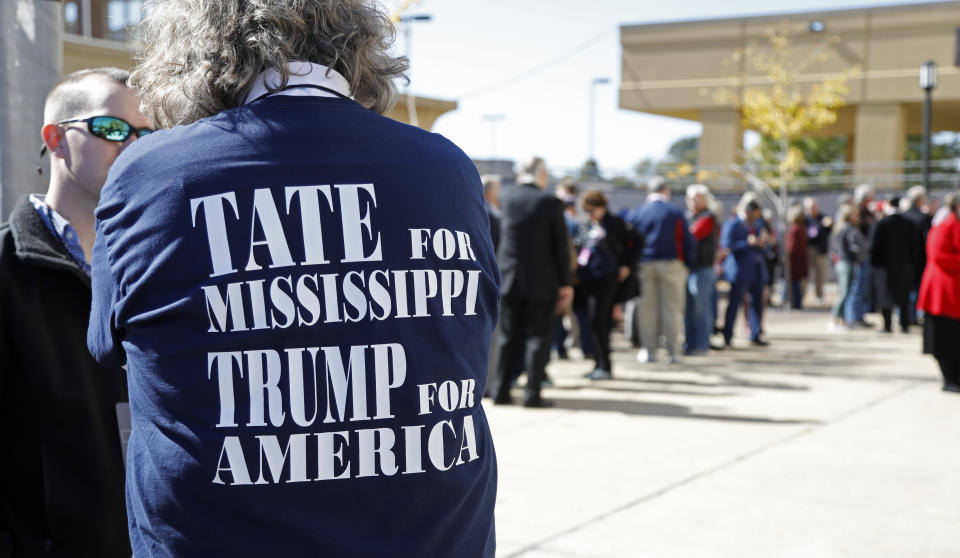 A man shows his support of Republican gubernatorial nominee Lt. Gov. Tate Reeves and President Donald Trump as he stands outside the BancorpSouth Arena in Tupelo, Miss., Friday, Nov. 1, 2019, while waiting to enter a Keep America Great Rally. (AP Photo/Rogelio V. Solis)