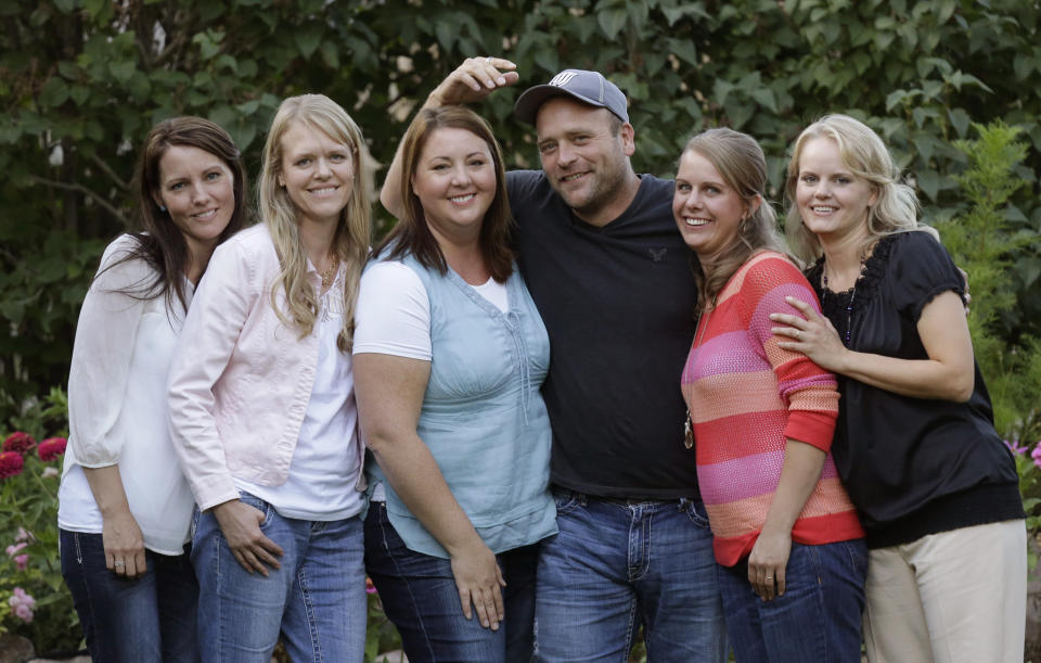 FILE - In this Sept. 11, 2013, file photo, Brady Williams poses with his wives, from left to right, Paulie, Robyn, Rosemary, Nonie, and Rhonda, outside of their home in a polygamous community outside Salt Lake City. The newest polygamous family from Utah on reality TV says sharing their story with a wide audience has been liberating. The first of nine episodes chronicling the life of Williams, his five wives and their 24 children airs Sunday on TLC. A pilot episode aired last fall of the show, being called "My Five Wives." Williams and his wives said in an interview with The Associated Press that they enjoy being able live openly and not worry about who knows about their lifestyle. (AP Photo/Rick Bowmer, File)