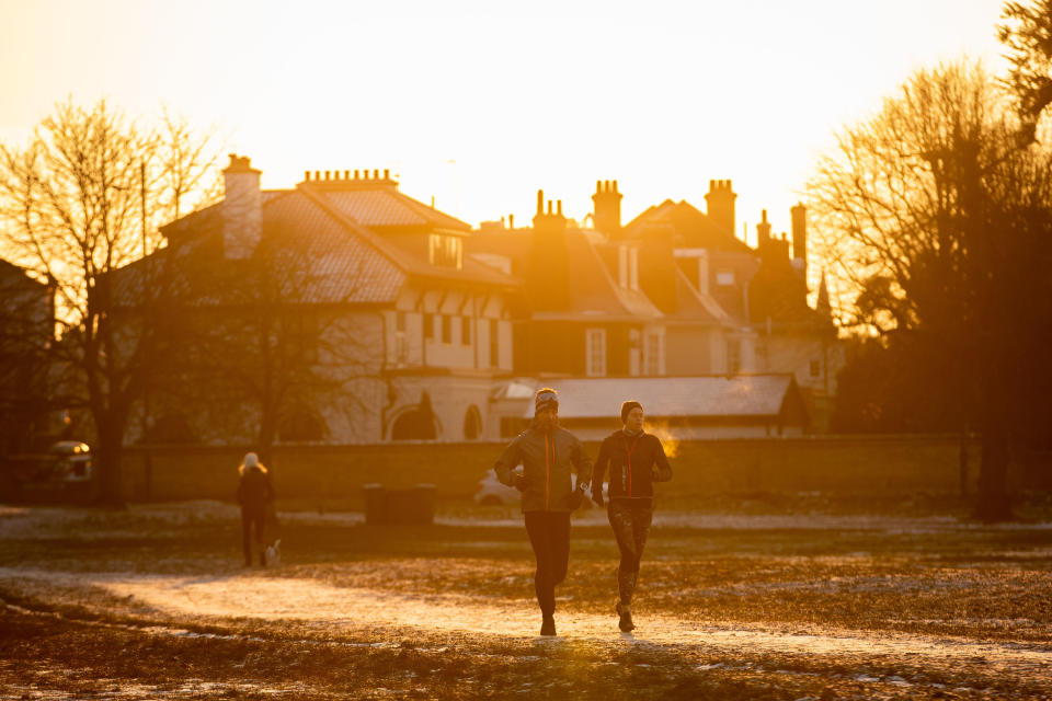 People out on a morning run near a frozen Rushmere Pond at Wimbledon Common, south London, as the cold snap continues to grip much of the nation. Picture date: Thursday February 11, 2021. (Photo by Aaron Chown/PA Images via Getty Images)