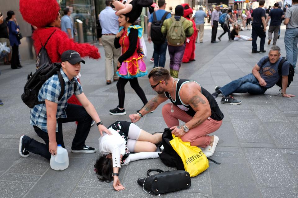 <p>People attend to an injured pedestrian a moment after a car plunged into them in Times Square in New York on May 18, 2017. (Jewel Samad/AFP/Getty Images) </p>