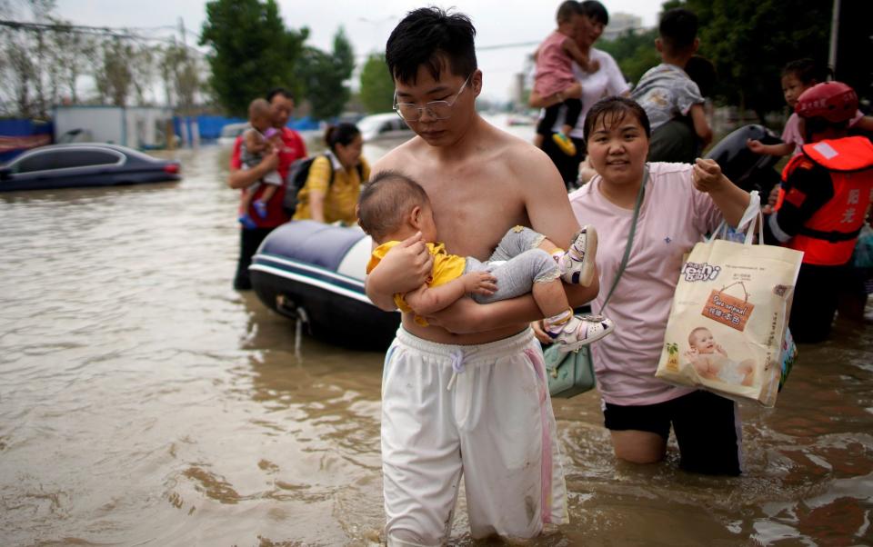 Families were forced to flee after extremely high levels of rain flooded parts of Henan - REUTERS/Aly Song/File Photo