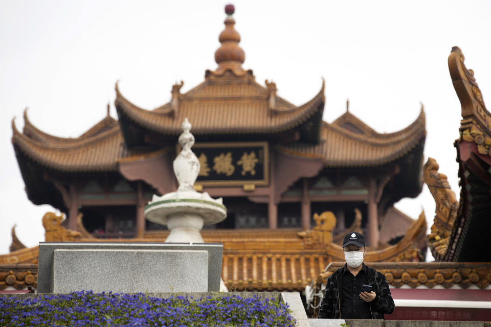 A resident looks out near the Yellow Crane Tower in Wuhan in central China's Wuhan province on Wednesday, April 1, 2020. Skepticism about China’s reported coronavirus cases and deaths has swirled throughout the crisis, fueled by official efforts to quash bad news in the early days and a general distrust of the government. In any country, getting a complete picture of the infections amid the fog of war is virtually impossible. (AP Photo/Ng Han Guan)