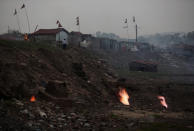 In this Oct. 23, 2019, photo, flames rise out of the fissures on the ground above coal mines in the village of Liloripathra in Jharia, a remote corner of eastern Jharkhand state, India. The fires started in coal pits in eastern India in 1916. More than a century later, they are still spewing flames and clouds of poisonous fumes into the air, forcing residents to brave sizzling temperatures, deadly sinkholes and toxic gases. (AP Photo/Aijaz Rahi)