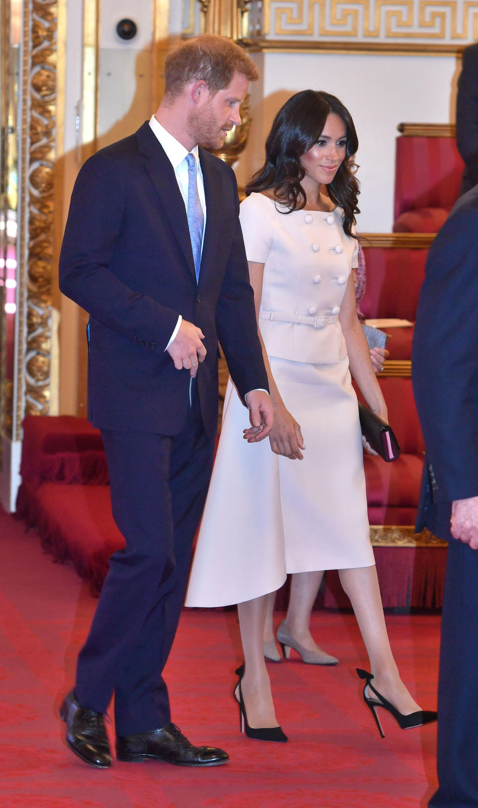 For the Queen’s Young Leaders ceremony at Buckingham Palace on 27 June, Meghan opted for a powder pink skirt suit by Prada [Photo: PA]