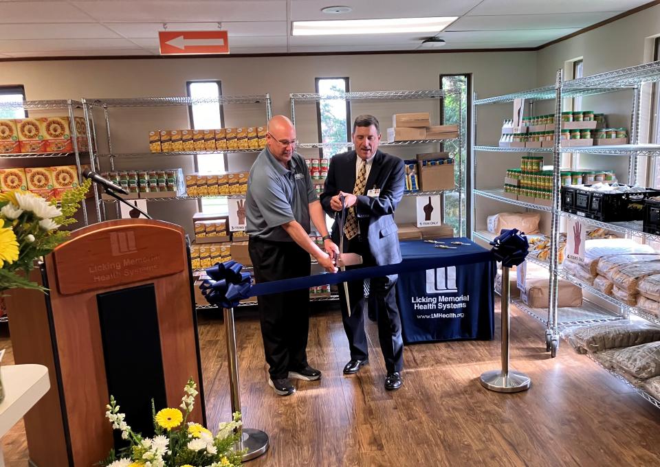 Food Pantry Network of Licking County Executive Director Chuck Moore and Licking Memorial Health Systems President and CEO Rob Montagnese cut the ribbon to open the network's newest market Tuesday at 130 McMillen Drive, next to the hospital in Newark.