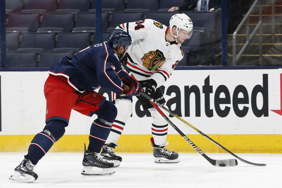 Chicago Blackhawks' Carl Soderberg, right, carries the puck as Columbus Blue Jackets' Seth Jones defends during the first period of an NHL hockey game Thursday, Feb. 25, 2021, in Columbus, Ohio. (AP Photo/Jay LaPrete)