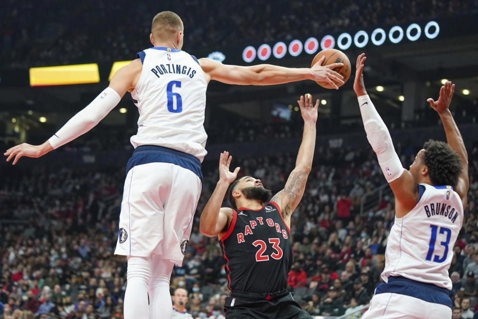 Toronto Raptors guard Fred VanVleet (23) has his shot attempt blocked by Dallas Mavericks center Kristaps Porzingis (6) as Jalen Brunson (13) defends during the first half of an NBA basketball game Saturday, Oct. 23, 2021, in Toronto. (Evan Buhler/The Canadian Press via AP)