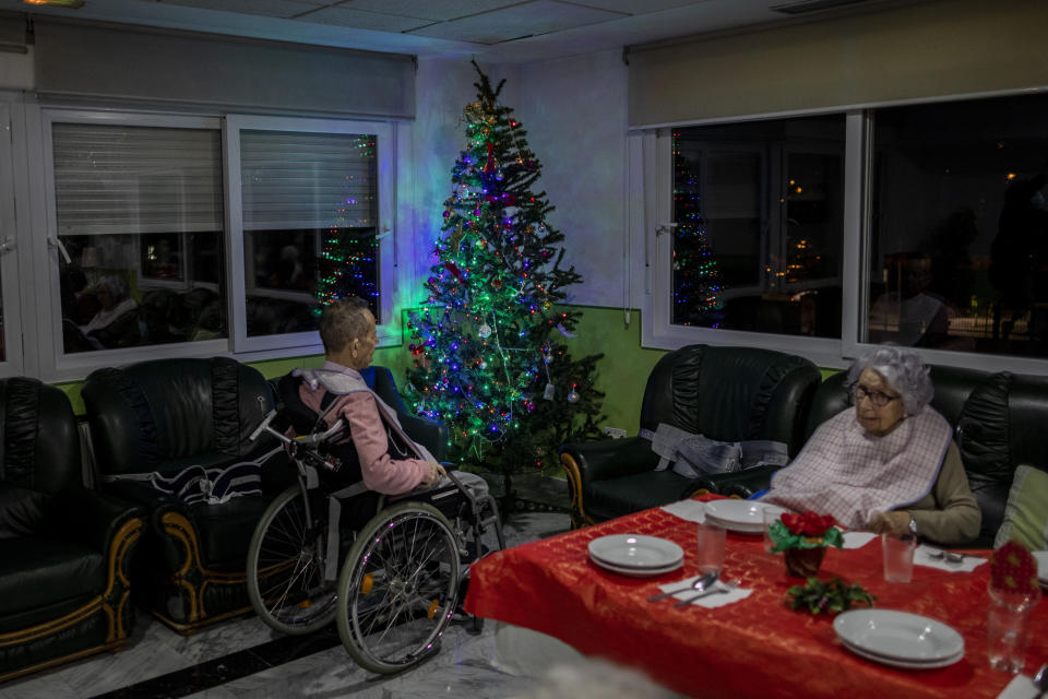 Two elders wait Christmas eve dinner at an elderly care home in Pozuelo de Alarcon, outskirts of Madrid, Thursday, Dec. 24, 2020. Many of the elderly in the residence haven't celebrate Christmas eve with their relatives to prevent the spread of coronavirus (AP Photo/Bernat Armangue)