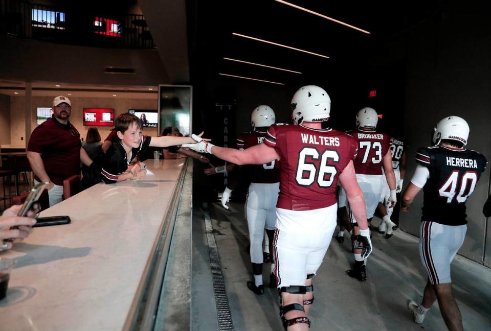 Weston Boling of Columbia reaches out for player high-fives before the 2023 spring game at Williams-Brice Stadium. Boling and his family were inside the 2001 Club before the game. The club space has an up-close view of the Gamecocks as they walk to and from the locker room.