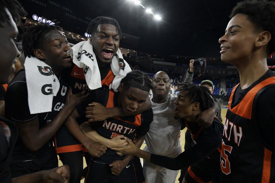 North High School players and coaches celebrate at the final buzzer after winning the Division 1 state championship.