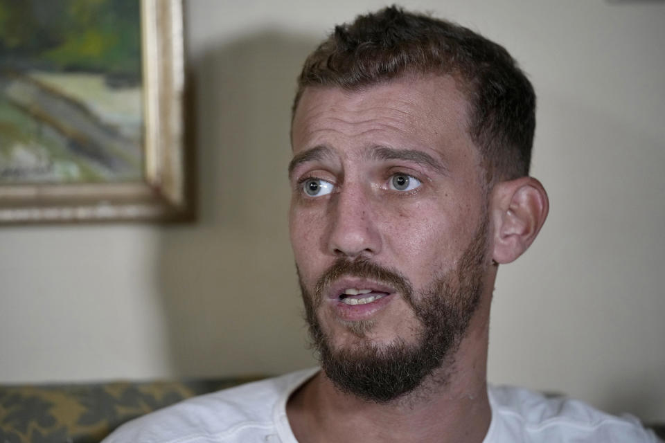 Jihad Michlawi, 31, speaks during an interview with The Associated Press at his home in the northern Beirut suburb of Burj Hammoud, Lebanon, Tuesday, Sept. 27, 2022. Michlawi is one of dozens of survivors from a migrant boat that left Tripoli, Lebanon heading towards Italy carrying over 100 Lebanese, Syrians, and Palestinians, that capsized near the Syrian coastal city of Tartus. At least 94 people were killed. (AP Photo/Bilal Hussein)