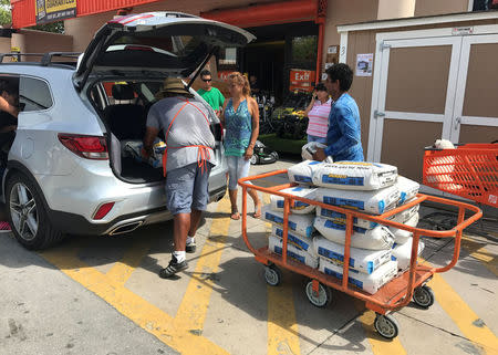 A Home Depot store employee helps to load bags of sand for customers in the Little Havana neighborhood in Miami, Florida, September 5, 2017. REUTERS/Joe Skipper