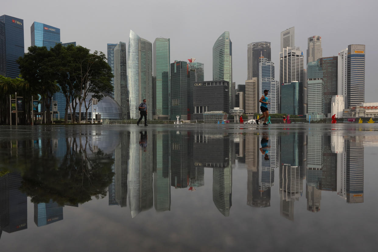 People walk along the Marina Bay waterfront with the central business district seen in the background on July 5, 2021 in Singapore.  (Photo by Suhaimi Abdullah/NurPhoto via Getty Images)