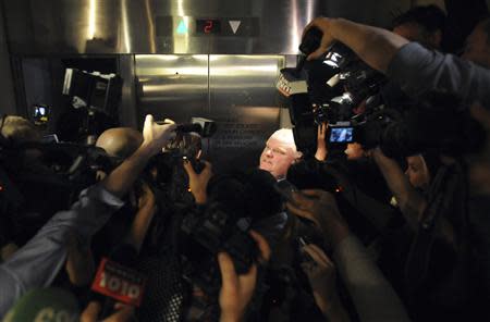Toronto Mayor Rob Ford (C) is surrounded by the media while waiting for an elevator as he returns to a city council meeting after a lunch break in Toronto November 15, 2013. REUTERS/Jon Blacker
