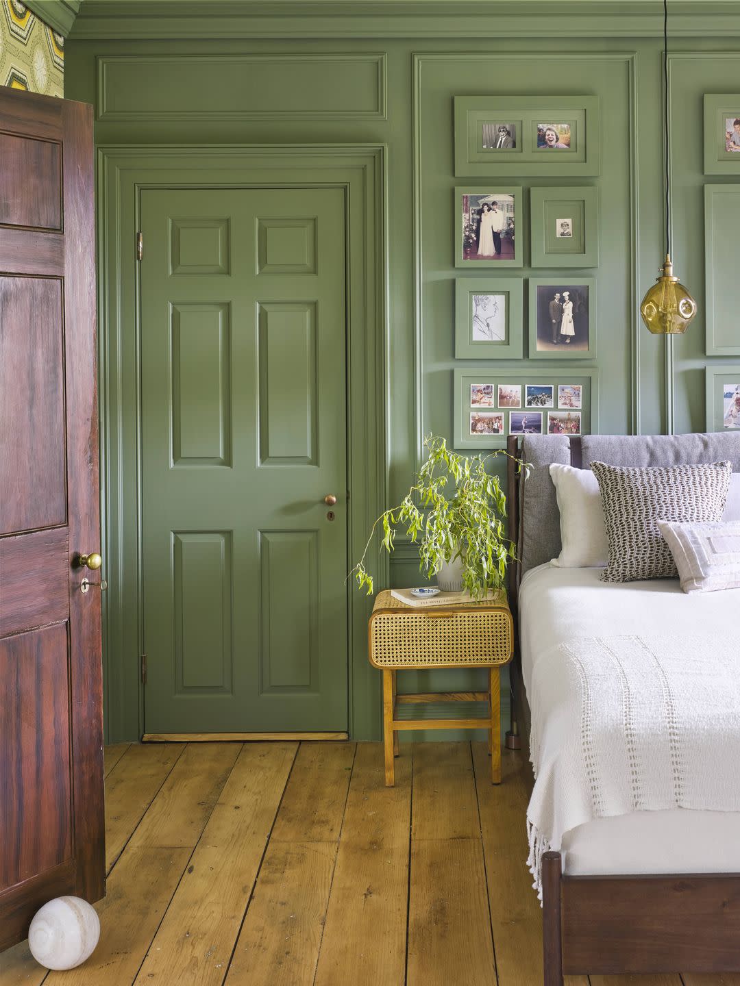 glossy green paint color for bedroom with matching wall, door, trim, gallery wall photo frames