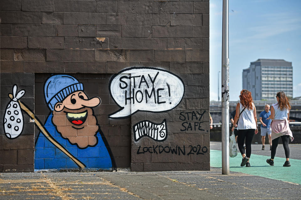 GLASGOW - MAY 27: Members of the public walk past new graffiti on Clyde Street on May 27, 2020 in Glasgow, United Kingdom. The British government continues to ease the coronavirus lockdown by announcing schools will open to reception year pupils plus years one and six from June 1st. Open-air markets and car showrooms can also open from the same date.  (Photo by Jeff J Mitchell/Getty Images)