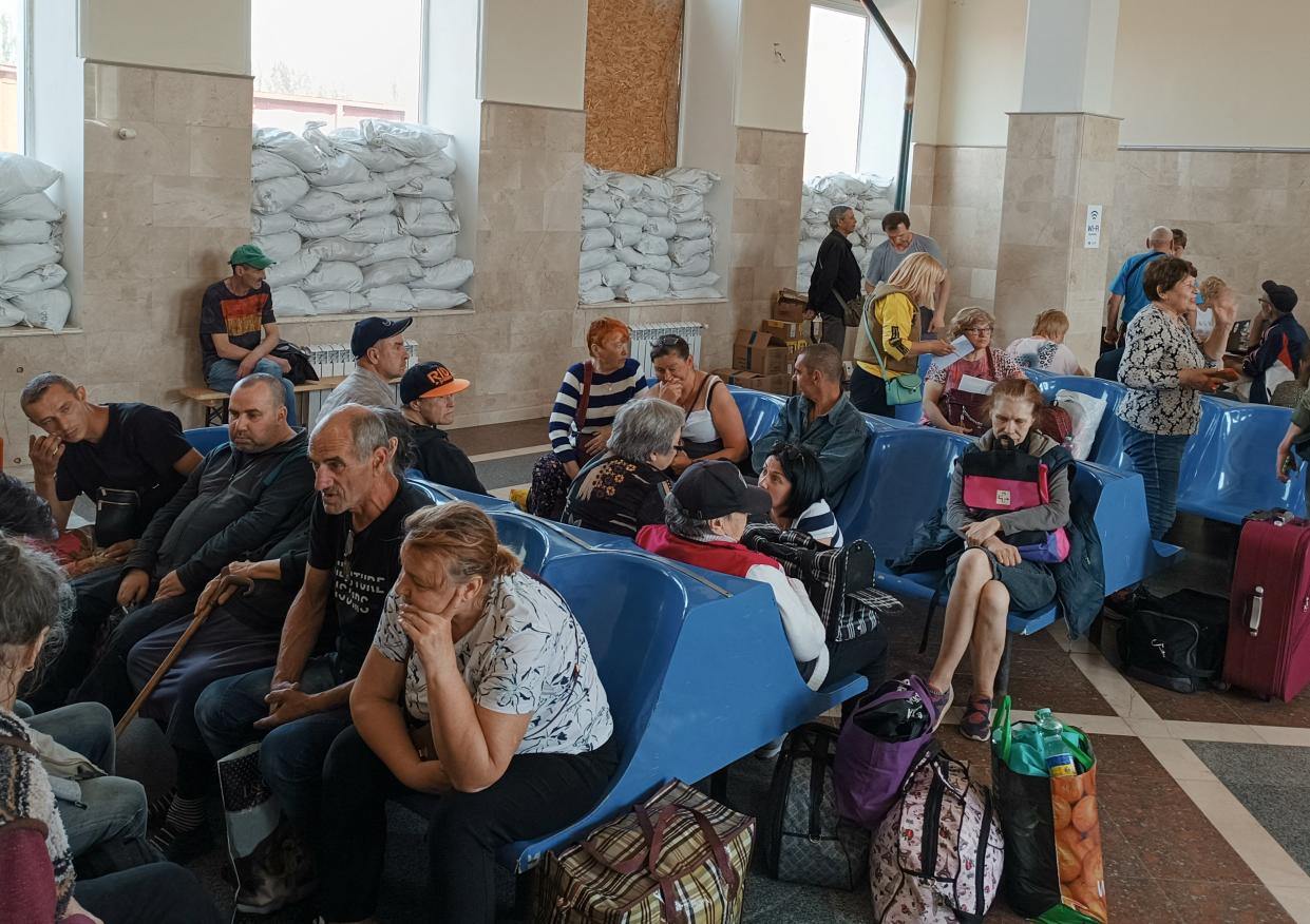 People wait for an evacuation train at a railway station in Kherson (Reuters)