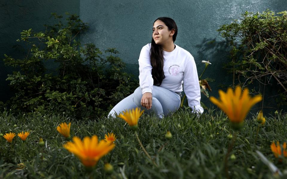 A young woman in a field of flowers.