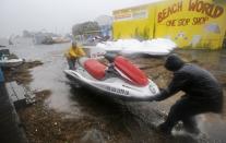 Ron Croker, left, and Tim Wood, move a jet ski on wheels to a safer location as water floods the dock, as Hurricane Sandy bears down on the East Coast, Monday, Oct. 29, 2012, in Ocean City, Md. (AP Photo/Alex Brandon)