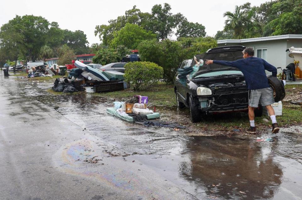 As the rain returns, resident Paul Guerrero continues the clean-out process at his home as discarded water-damaged items pile up on the neighborhood’s street on Monday, April 17, 2023. Carl Juste/cjuste@miamiherald.com
