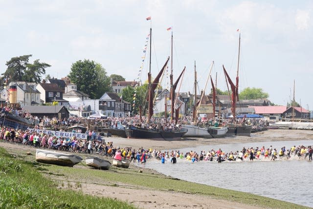 Competitors take part in the annual Maldon Mud Race, a charity event to race across the bed of the River Blackwater in Maldon, Essex