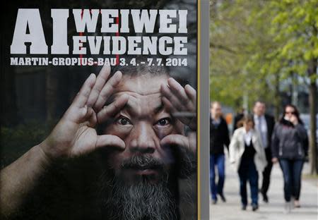 People walk beside an advertising poster for the exhibition 'Evidence' by Chinese artist Ai Weiwei at the Martin-Gropius Bau in Berlin, April 2, 2014. REUTERS/Fabrizio Bensch