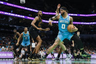 Charlotte Hornets forward Miles Bridges (0) drives to the basket against Cleveland Cavaliers forward Evan Mobley, center, during the first half of an NBA basketball game in Charlotte, N.C., Wednesday, March 27, 2024. (AP Photo/Nell Redmond)