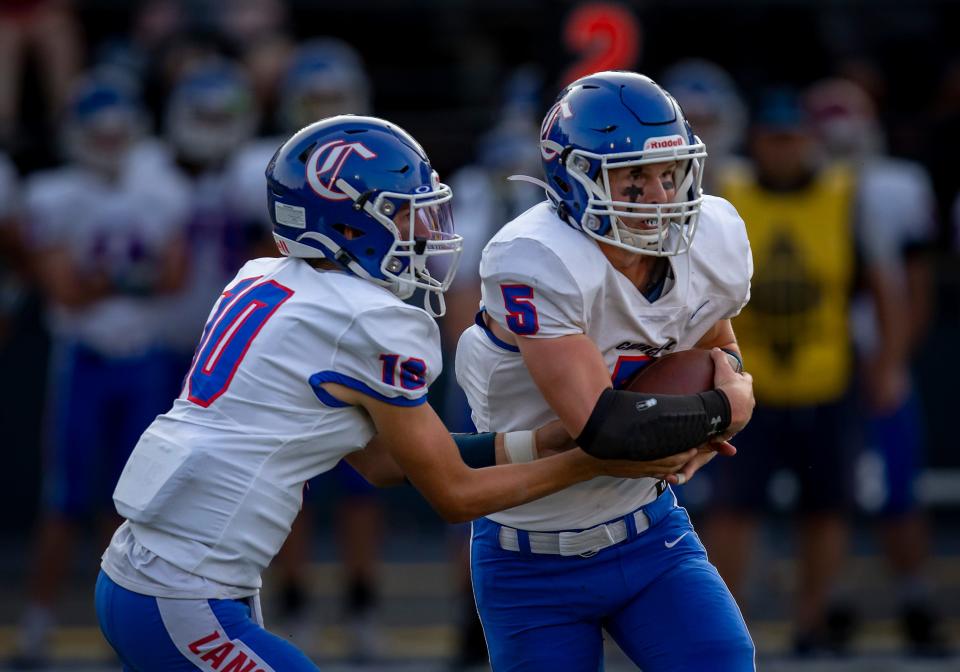 Churchill quarterback Tyler Mikel hands off the ball to running back Noa Allison during the first half. The Marist Spartans defeated the Churchill Lancers 38-7 at Marist Catholic High School on September 2022 in Eugene.