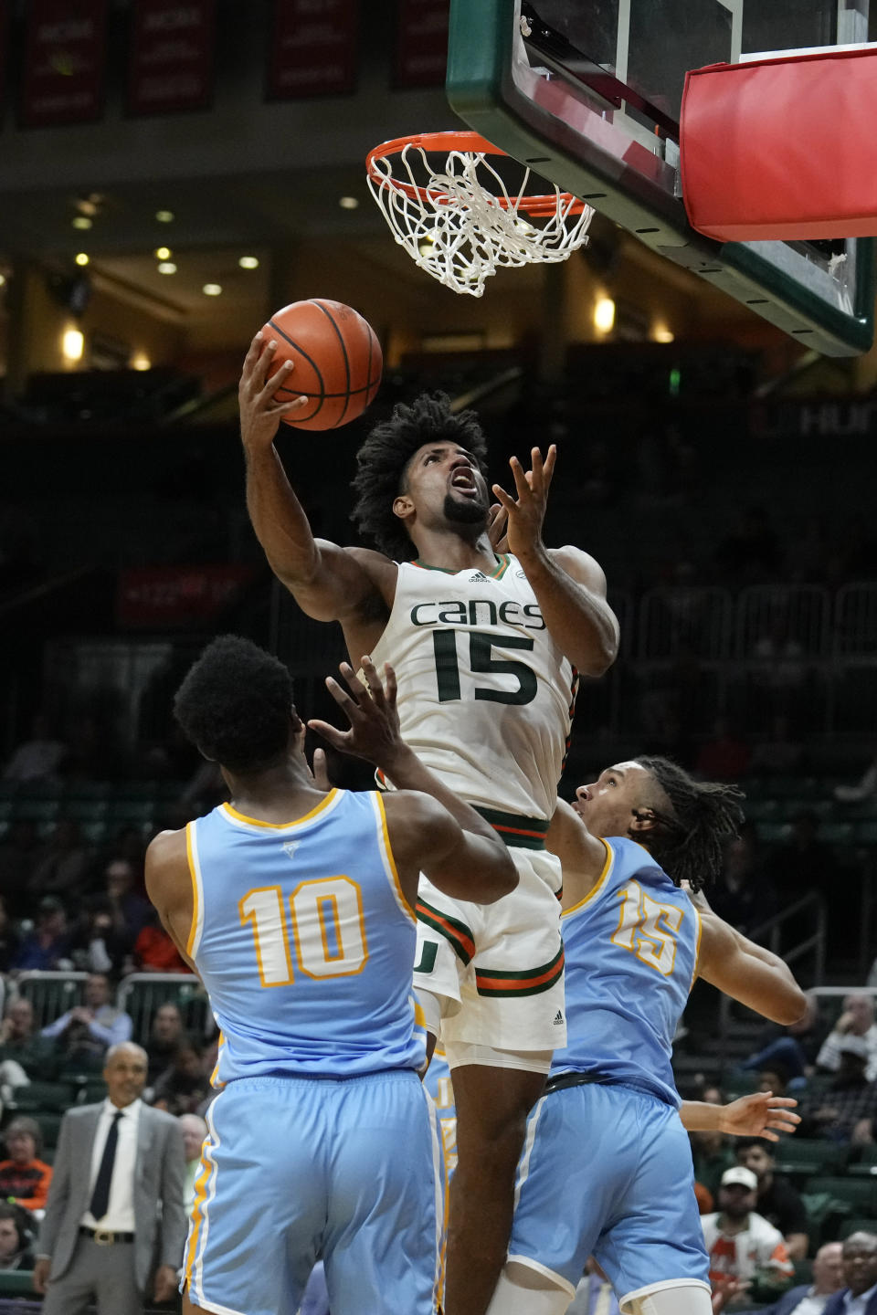 Miami forward Norchad Omier (15) jumps over LIU Brooklyn guard RJ Greene (10) and center CJ Delancy (15) to score during the first half of an NCAA college basketball game in Coral Gables, Fla., Wednesday, Dec. 6, 2023. (AP Photo/Rebecca Blackwell)