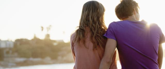 South Africa, Cape Town, Rear view of young couple sitting at beach