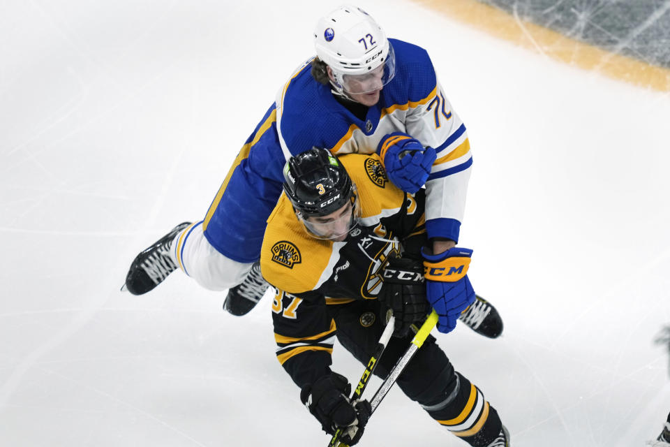 Buffalo Sabres center Tage Thompson (72) leaps onto the back of Boston Bruins center Patrice Bergeron (37) while chasing the puck during the first period of an NHL hockey game Thursday, March 2, 2023, in Boston. (AP Photo/Charles Krupa)